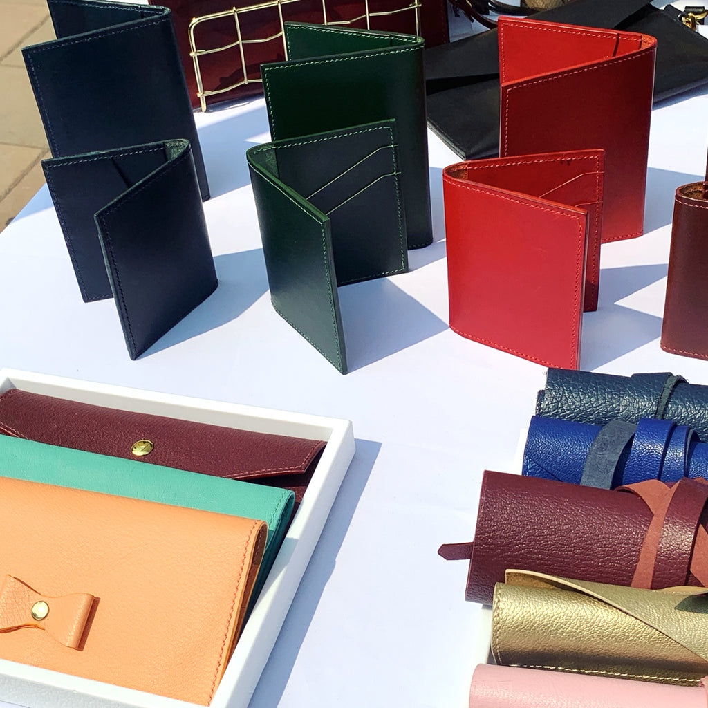colorful leather wallets and card cases on a white table